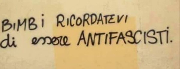 Scritta sul muro: bambini ricordatevi di essere antifascisti 