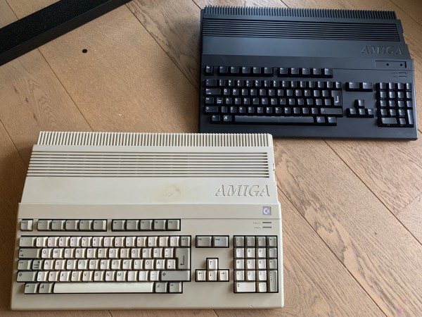 A beige A500 and a black A500 side by side on a wooden floor.