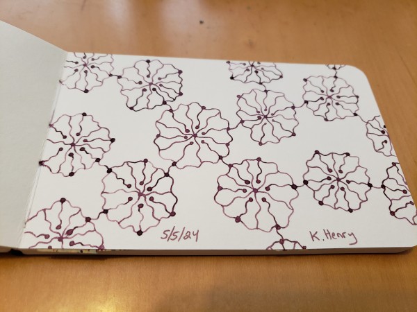 Hand drawn generative/iterative art in ink on an open page of my sketchbook. The abstract pattern is inspired by a fading flower and chemical diagrams.