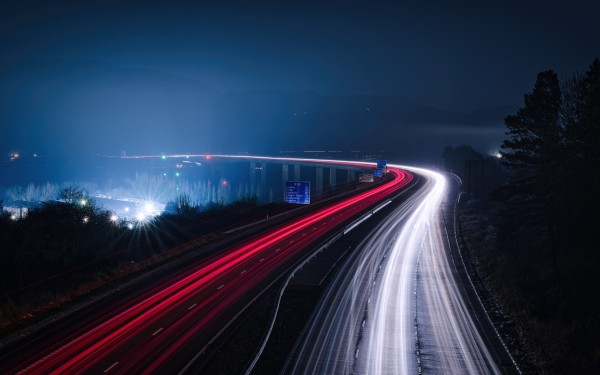 A long exposure view of car lights trailing into the foggy distance over Friarton Bridge on the outskirts of Perth, by night.
