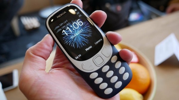 Eine Hand hält ein Feature-Phone von Nokia in der Hand.