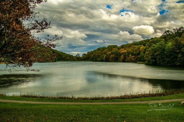 Photograph of Abbott Lake at the Peaks of Otter Lodge in Virginia, showing calm waters reflecting cloud-filled skies and autumn-colored trees. Image at:  https://beautifulsunphotography.com/featured/autumn-whisper-at-abbott-lake-deb-beausoleil.html See more art & blog at: https://beautifulsunphotography.com/ https://debbeautifulsunphotography.com/ https://www.zazzle.com/store/beautifulsun_designs https://debbeausoleil.com