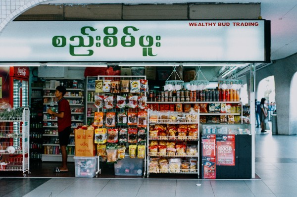 a scan of a film photo of burmese script at a burmese grocery store in singapore