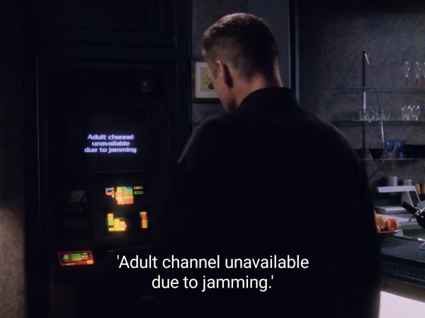 Picture of Sheridan in his quarters, taken from behind. He is looking at a video display.

The caption reads: "Adult channel unavailable due to jamming."
