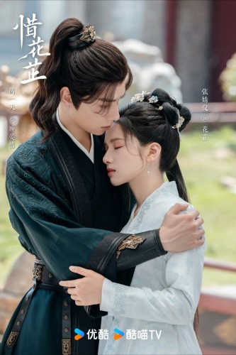 Hu Yitian and Zhang Jingyi embrace. He is on the left in a dark green costume and she is in a pale blue costume. She is leaning her head on his shoulder.