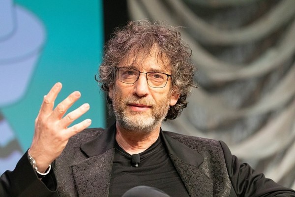 Neil Gaiman on stage seated