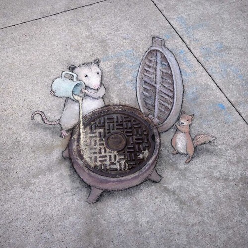 Zeichnung auf dem Boden.
Ein Metalldeckel stellt einen Waffel-Kocher dar. Ein Possum giesst aus einem Krug die Waffel-Masse darauf und ein Eichhörnchen steht bereit, um den Deckel zu schliessen.