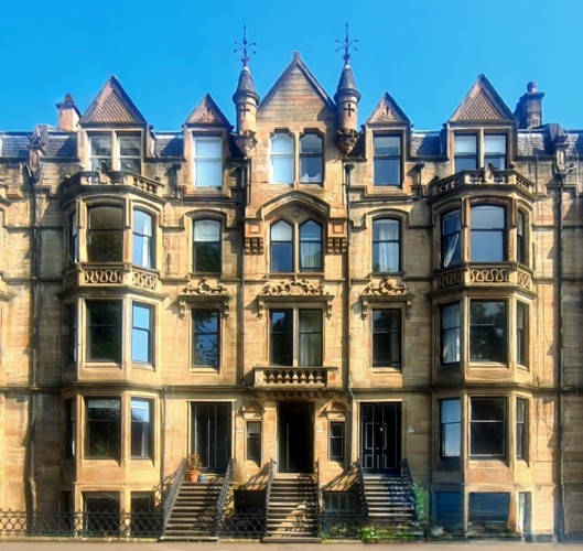 A Scots Baronial blonde sandstone tenement building.