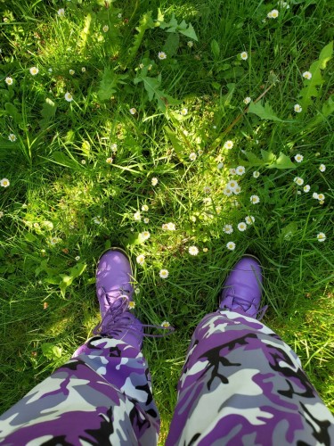 My purple boots & purple camo pants. Standing on rewilded greenspace in our backyard. Lots of daisies, dandelions, wild violets, sedge & buckwheat.
