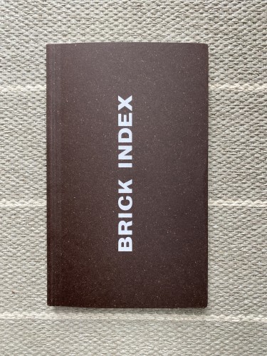 Cover of a tallest almost brick shaped book. It is brown with the title “Brick Index” printed vertically in bold white type.