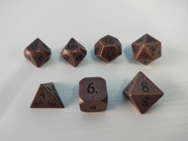 The full set of copper dice: d4, d6, d8, d10 (0-9), d10 (00-90), d12, d20.