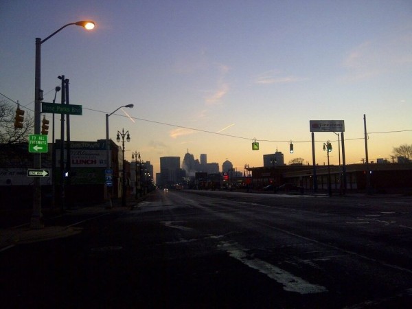 Una gran avenida vacía, con rascacielos al fondo, al amanecer.