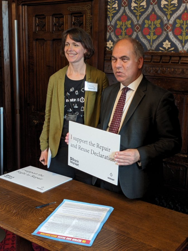 Fiona from The Restart Project with Bambos Charalambous MP, who is holding a sign that says 'I support the Repair and Reuse Declaration'