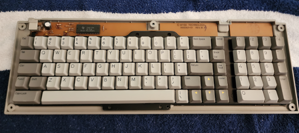 A partially disassembled keyboard. The cleaned keycaps have been placed into it, but the plastic outer body is still open. It's a terminal layout, with a numpad on the right