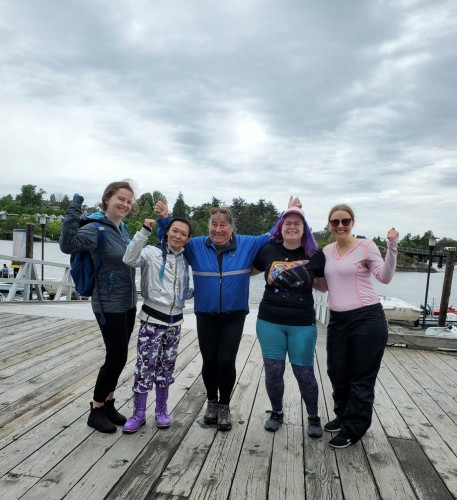 Me with 4 other female team mates on upper wharf at Fairway Gorge Paddling Club. The Gorge Waterway is behind us. Our team is called: Storm the Gorge.