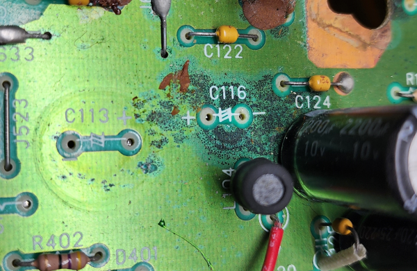 A PCB with two empty spots where capacitors were, and it's got bits where the solder resist has been eaten away by some chemical 