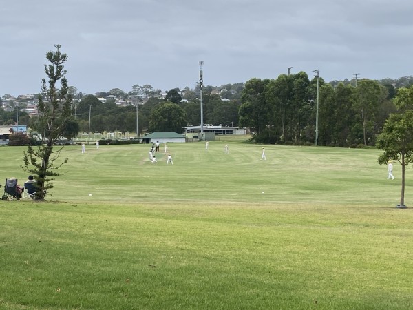 Photo of cricketers in white on a small oval in the park. Nice village feel to it. Can't make out much about the players thanks to my photographic skills. Was delighted to see girls playing too - times changing in a good way. 