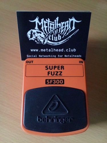 Stickers with the metalhead.club mammoth skull logo and text reading "www.metalhead.club Social Networking for Metalheads", proped up on a Beheringer Super Fuzz SF300 guitar pedal.