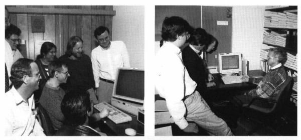 Black and white photo from the Fermilab newsletter, showing two groups of people gathered around computer monitors as they submitted their papers to Nature.