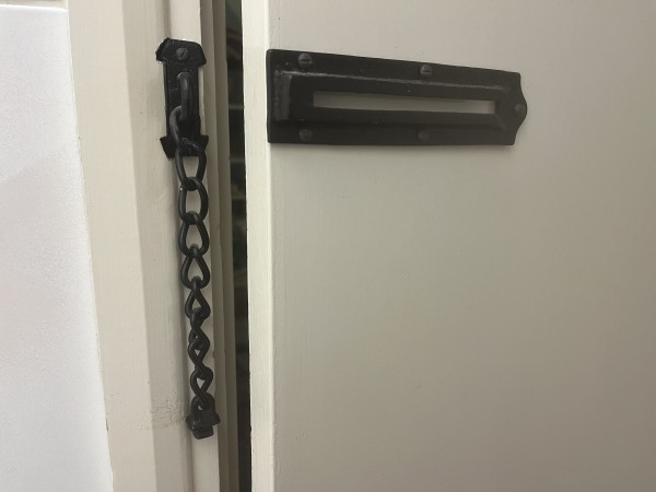 a black sliding chain lock, like the kind old ladies have on their front doors