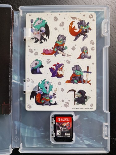 Opened Nintendo Switch game case with Death's Gambit game card and a set of stickers representing several characters.