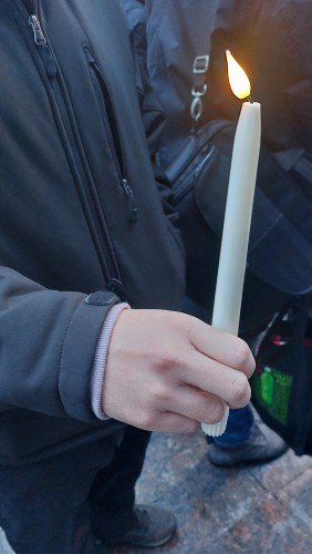 A mourner holds an electric candle