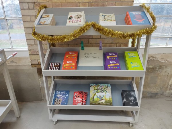 A bookshelf with books about water treatment and sewage, with a sign saying

"The books at poo corner"