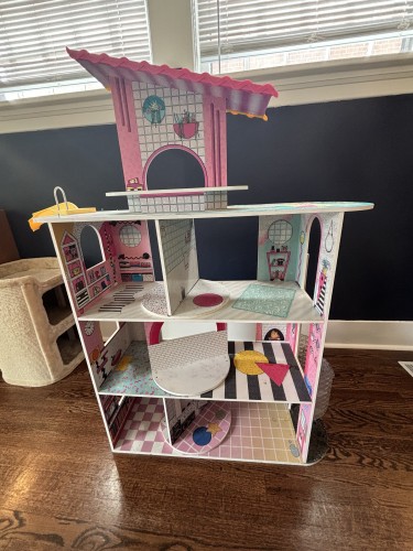 The fully assembled doll house, with a roof top attachment not pictured in the bike mount photos. The rooms of the dollhouse are decorated in funky patterned papers like terrazzo, pink checkers, and vaporwave-ish retro shapes.