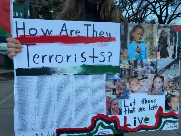 Protest sign: " How are they Terrorists?" w pictures of Palestinian children "Let those that are left LIVE"