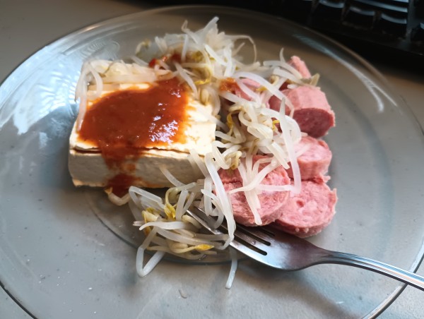 A plate of tofu, bean sprouts, and sausage.